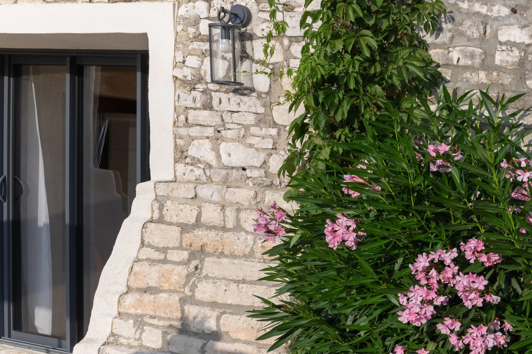 Façade en pierre cévenole avec lanterne et laurier — bassin alésien