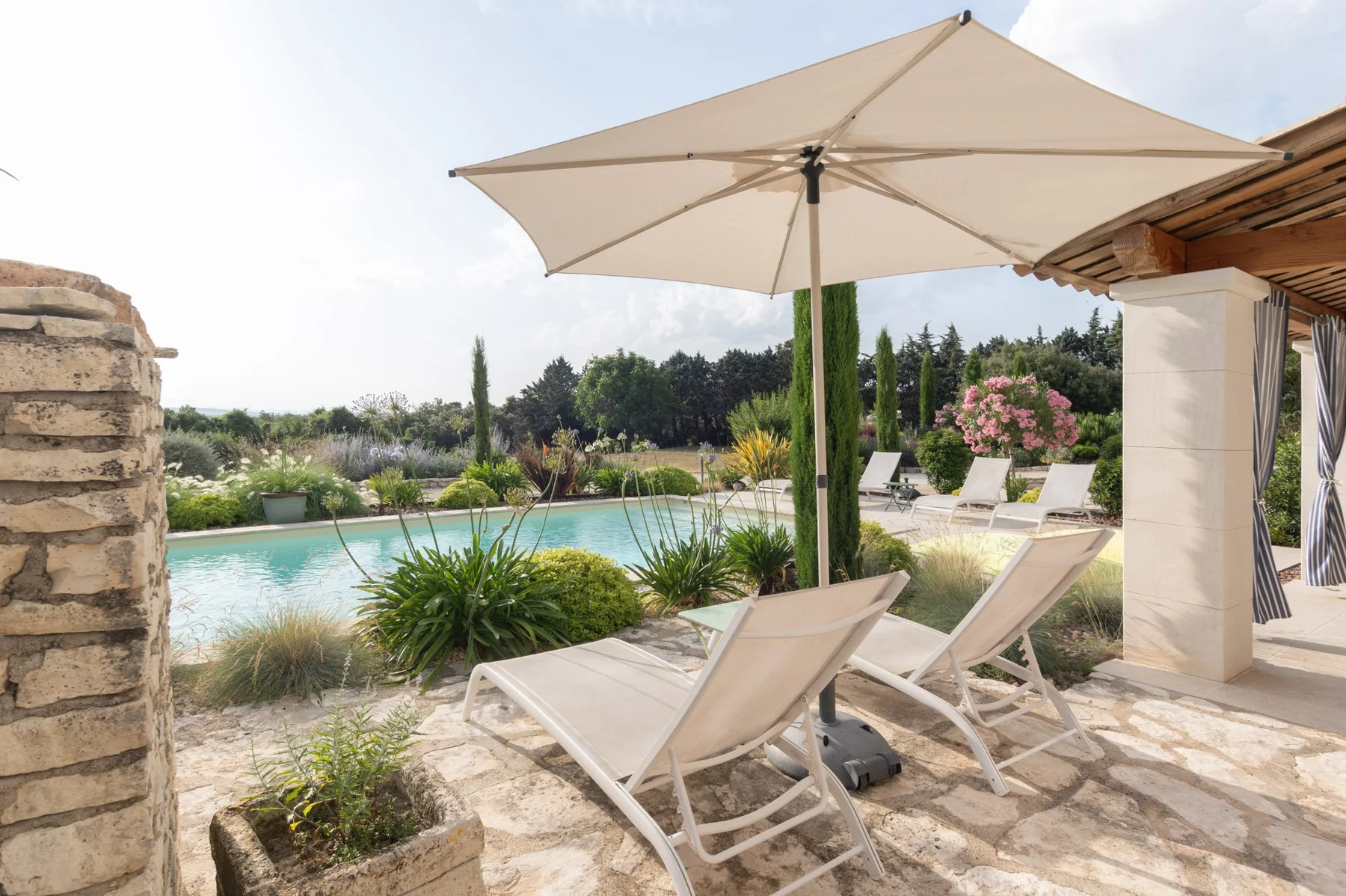 Transats et parasol au bord de la piscine — location saisonnière Drôme