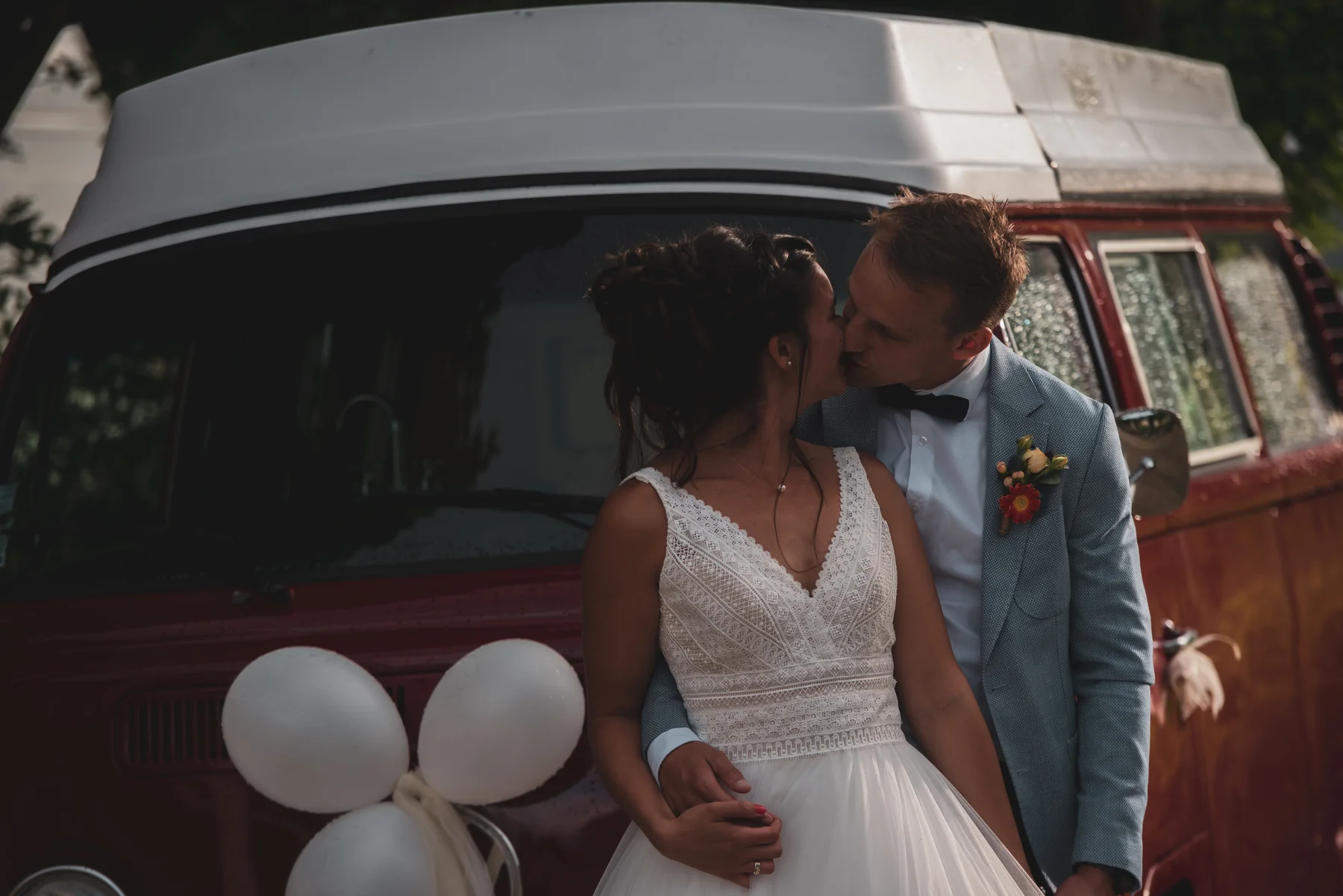 Couple de mariés devant un combi VW vintage rouge bordeaux, mariage bohème en Ardèche