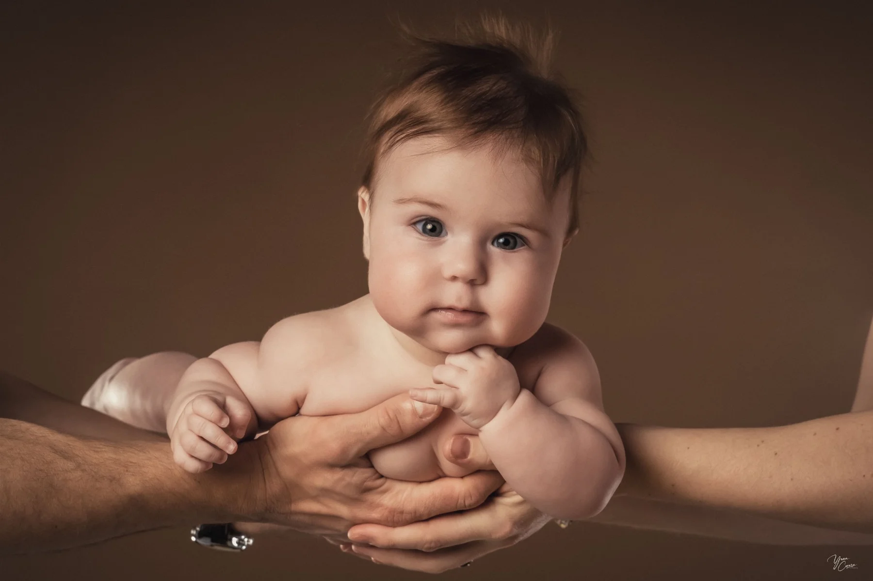 Bébé dans les mains de ses parents