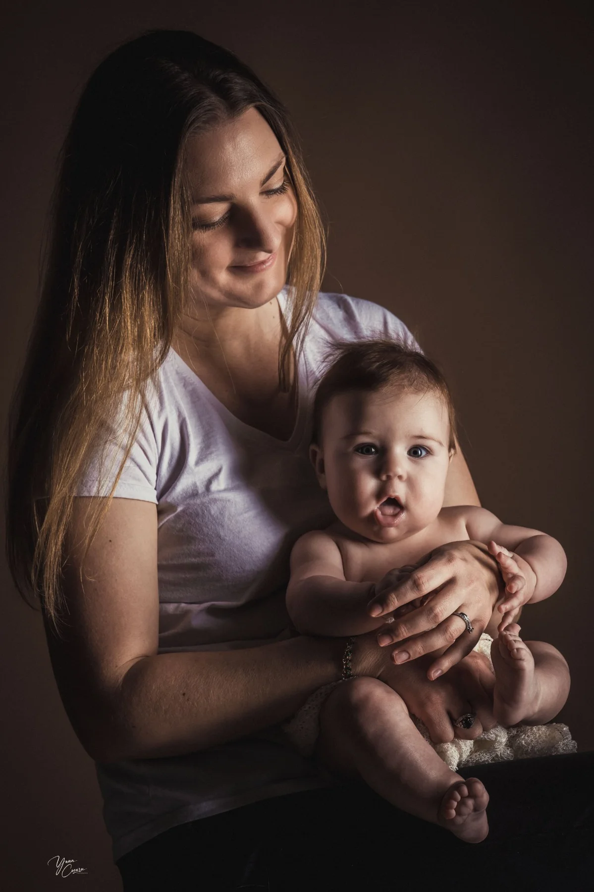 Maman tenant son bébé avec tendresse en studio photo
